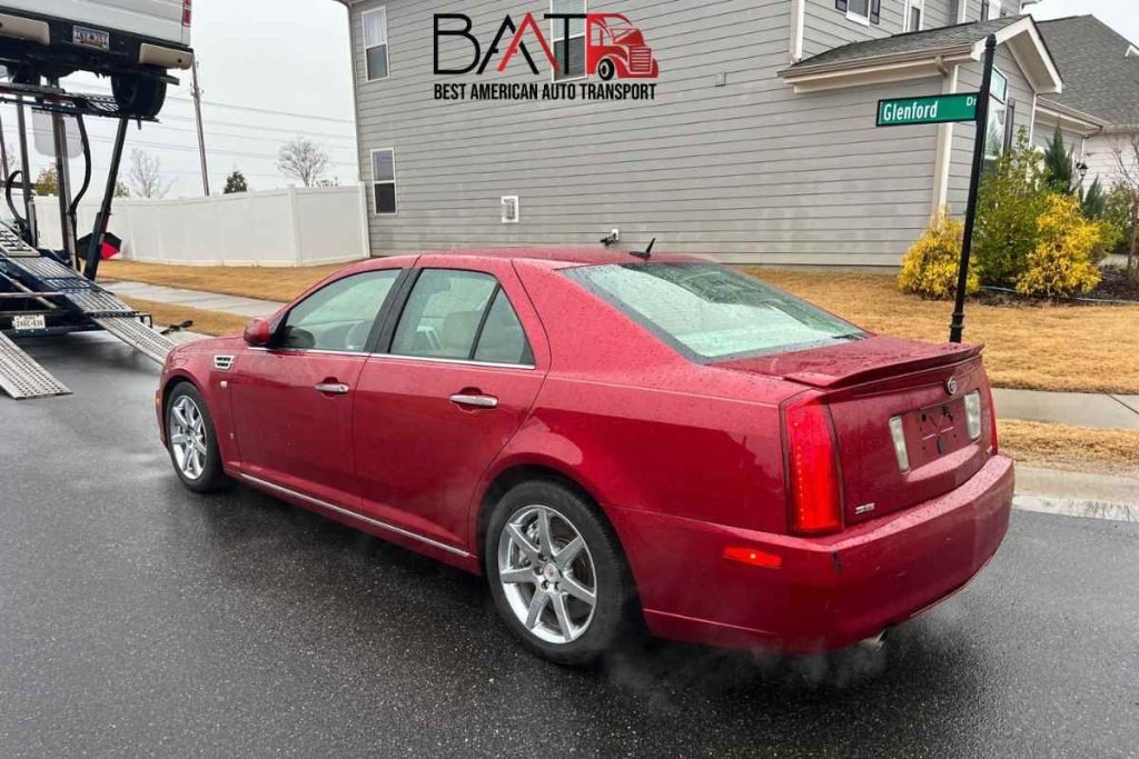 Home 9 This Image show A red color cadillac sts loaded onto open trailer for shipping